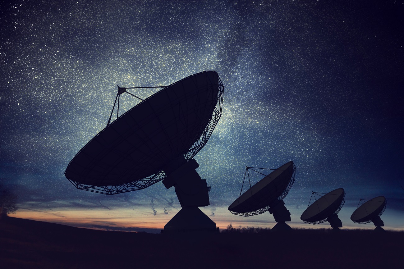 silhouettes,of,satellite,dishes,or,radio,antennas,against,night,sky.