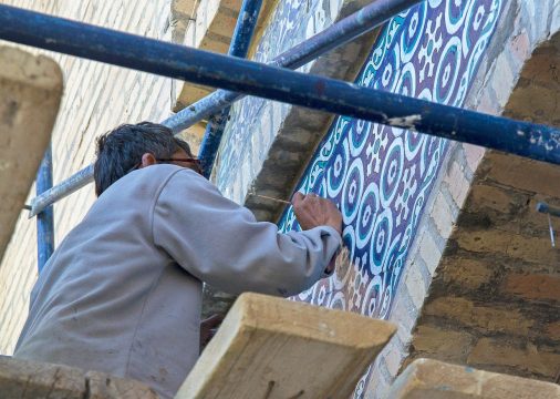 fine,art,restorer,renovating,colorful,painting,of,ancient,building.,high rise