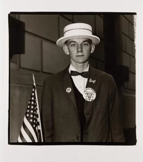 diane arbus, boy with a straw hat waiting to march in a pro war parade, n.y.c., 1967